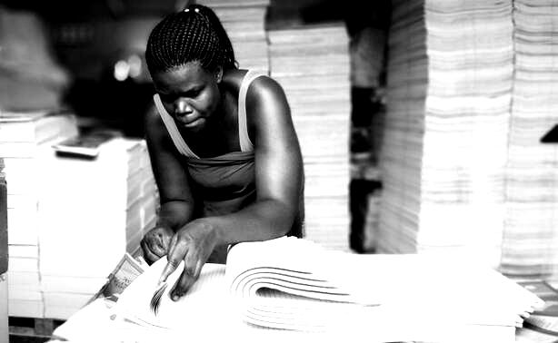 Lady counting sleeves of printed A5 papers at a factory - Iungo capital portfolio companies